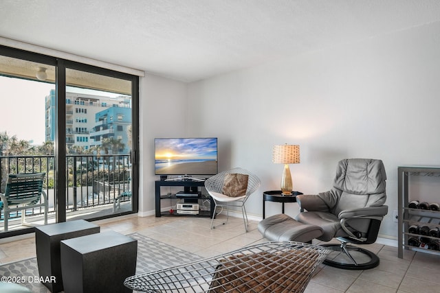 tiled living area featuring floor to ceiling windows, baseboards, and a textured ceiling