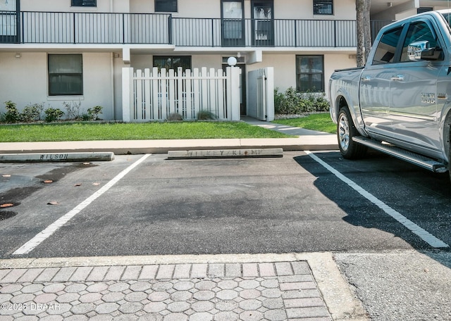 uncovered parking lot featuring fence