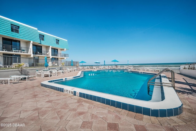 view of pool featuring a patio and a water view