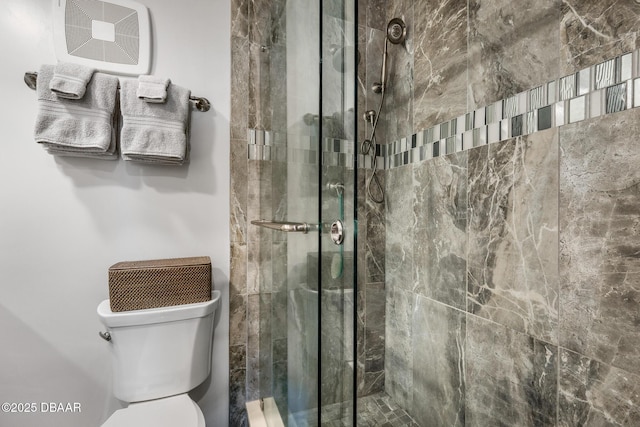 bathroom featuring a stall shower and toilet