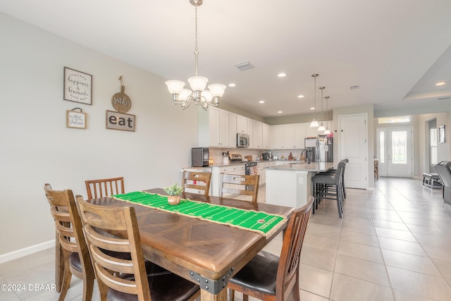 dining space featuring light tile patterned floors, sink, and an inviting chandelier