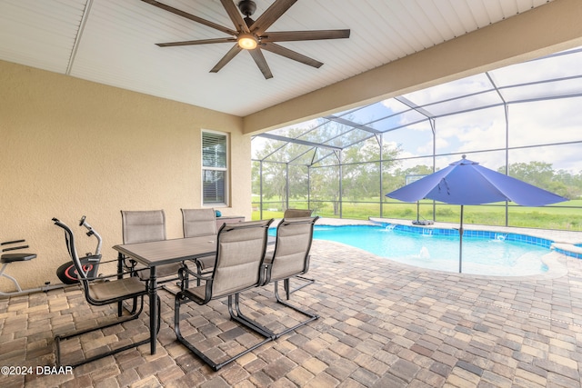 view of swimming pool featuring glass enclosure, a patio, ceiling fan, and pool water feature