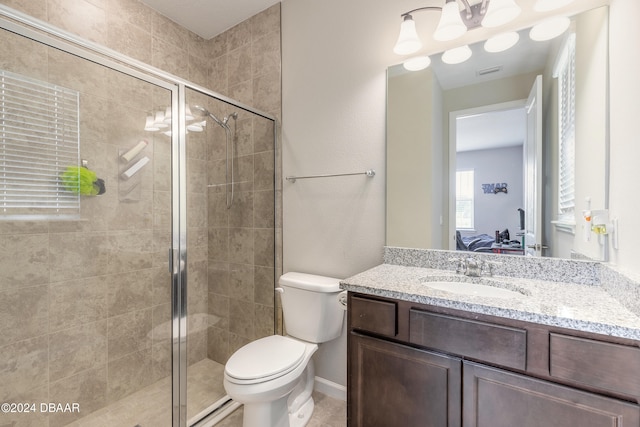 bathroom featuring a shower with shower door, vanity, and toilet