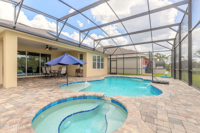 view of swimming pool featuring a patio, ceiling fan, glass enclosure, and an in ground hot tub