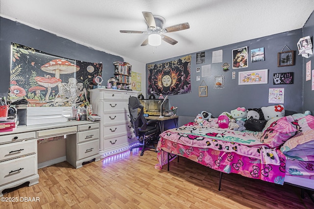 bedroom featuring ceiling fan, light hardwood / wood-style floors, and a textured ceiling