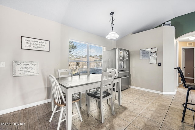 tiled dining space featuring lofted ceiling