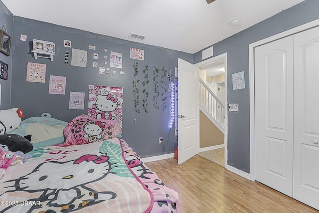 bedroom with light hardwood / wood-style flooring and a closet