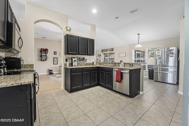 kitchen featuring light tile patterned flooring, appliances with stainless steel finishes, hanging light fixtures, kitchen peninsula, and light stone countertops