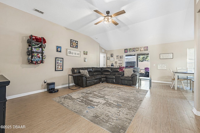 living room featuring hardwood / wood-style flooring, ceiling fan, and vaulted ceiling