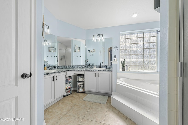 bathroom with vanity, tile patterned floors, and plus walk in shower