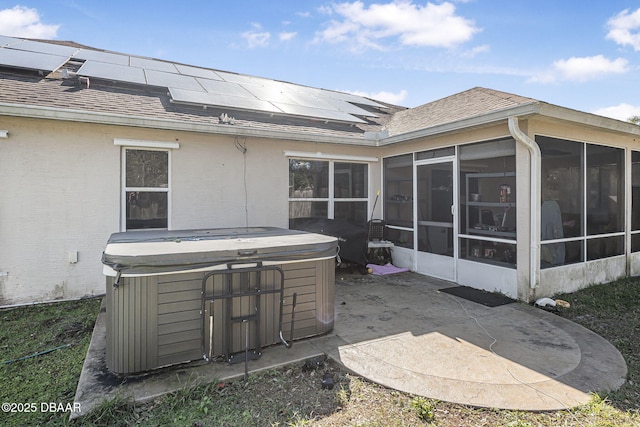 view of patio / terrace with a hot tub and a sunroom