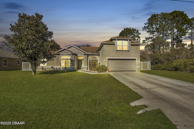 view of front of home with a garage and a yard