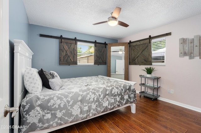 840 River Oak Dr W, Ormond Beach, FL 32174 - bedroom featuring a barn door, multiple windows, a textured ceiling, and wood finished floors
