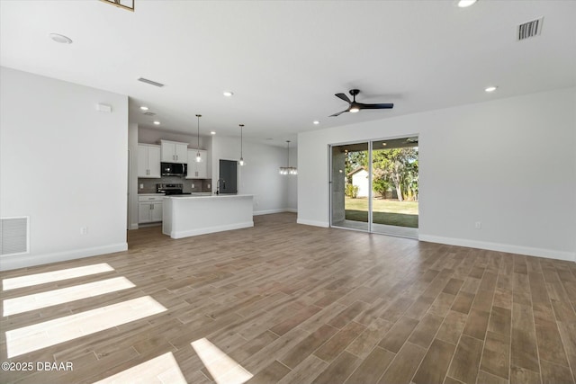 2 Seamanship Trl, Palm Coast, FL 32164 - unfurnished living room with ceiling fan, baseboards, recessed lighting, a sink, and light wood finished floors
