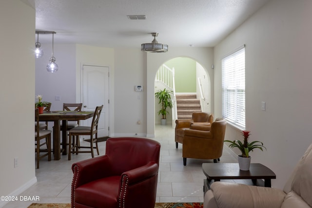 tiled living room featuring a textured ceiling