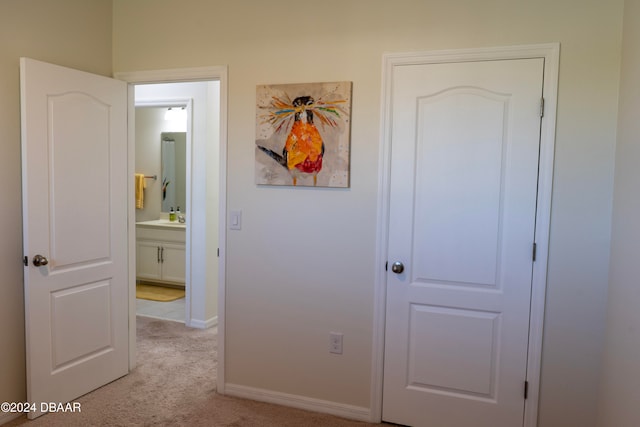 hall with light colored carpet