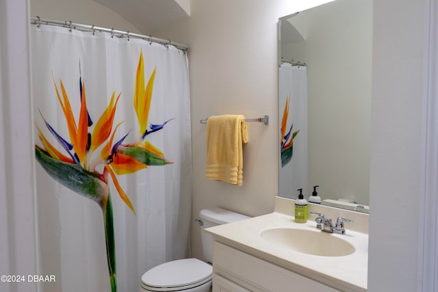 bathroom featuring curtained shower, vanity, and toilet