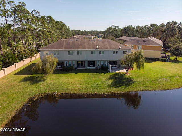 back of house featuring a lawn and a water view