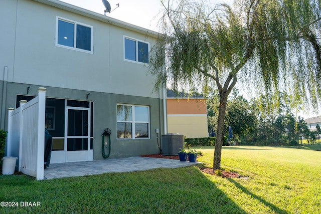 back of house featuring central AC unit, a patio, and a lawn