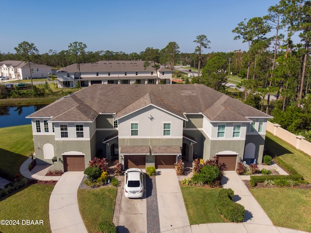 view of front of home featuring a front yard, a garage, and a water view