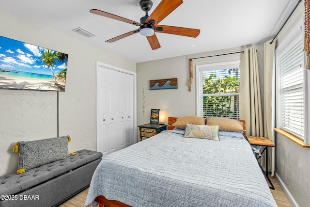 bedroom with ceiling fan, a closet, and light wood-type flooring