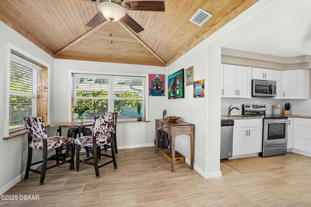 dining area featuring ceiling fan and wooden ceiling