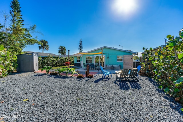 back of house featuring a patio area and a storage shed