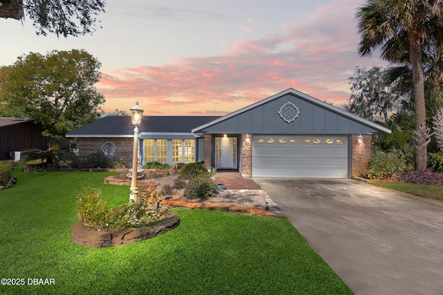 ranch-style house featuring a garage and a yard