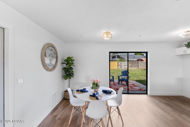 dining area featuring light wood-style flooring and baseboards