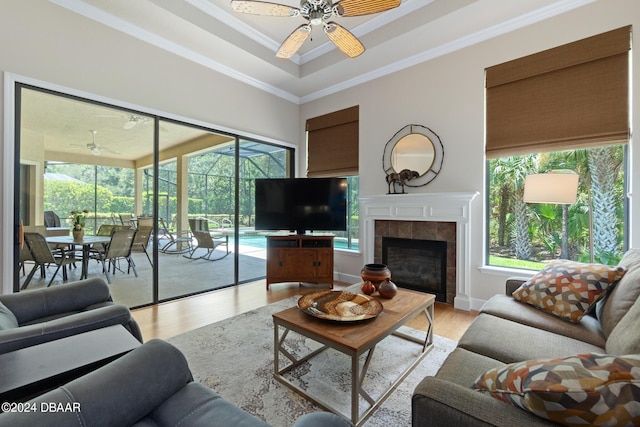 living room with plenty of natural light, light wood-type flooring, ceiling fan, and crown molding