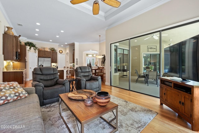 living room with light wood-type flooring, ceiling fan, and crown molding