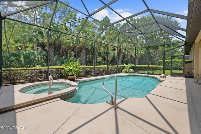 view of swimming pool with an in ground hot tub, glass enclosure, and a patio