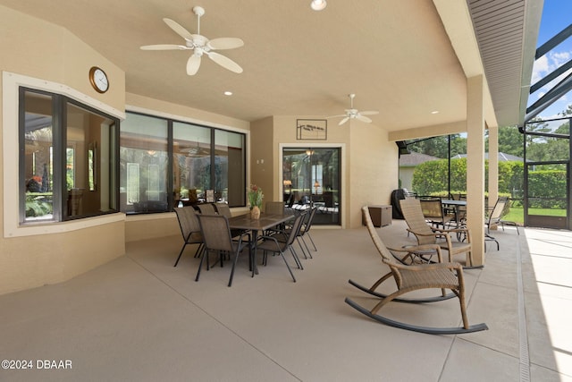 view of patio with ceiling fan and glass enclosure