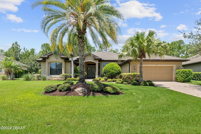 ranch-style house featuring a garage and a front yard