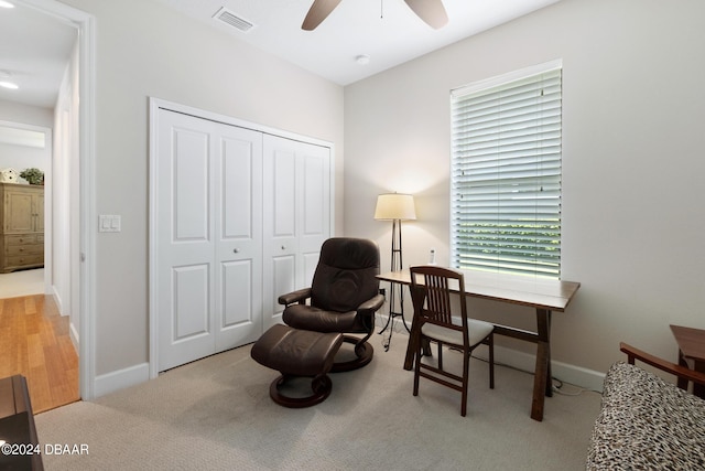 living area with ceiling fan and light carpet