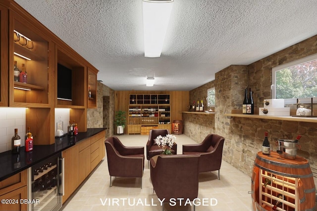 wine room with light tile patterned floors, a textured ceiling, wine cooler, and indoor bar