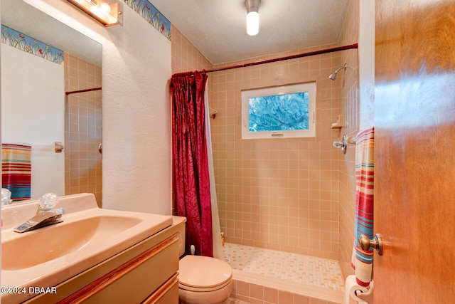 bathroom featuring curtained shower, vanity, a textured ceiling, and toilet