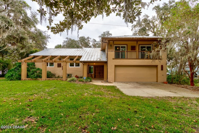 view of front of house featuring a garage, a balcony, and a front yard