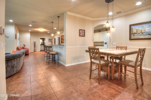 tiled dining room featuring crown molding