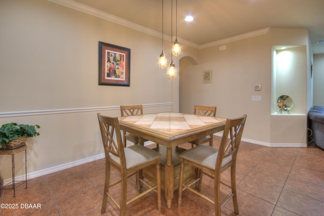 tiled dining space featuring ornamental molding