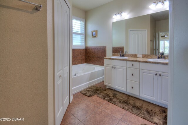 bathroom with a bath, tile patterned flooring, and vanity