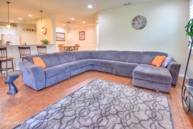 living room with ornamental molding and tile patterned floors