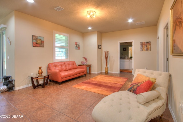 living room featuring a textured ceiling and tile patterned floors