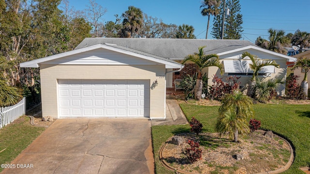 ranch-style home featuring a garage, brick siding, a front yard, and fence