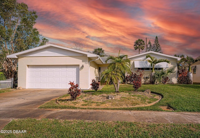 view of front of home featuring a garage, fence, a front lawn, and concrete driveway