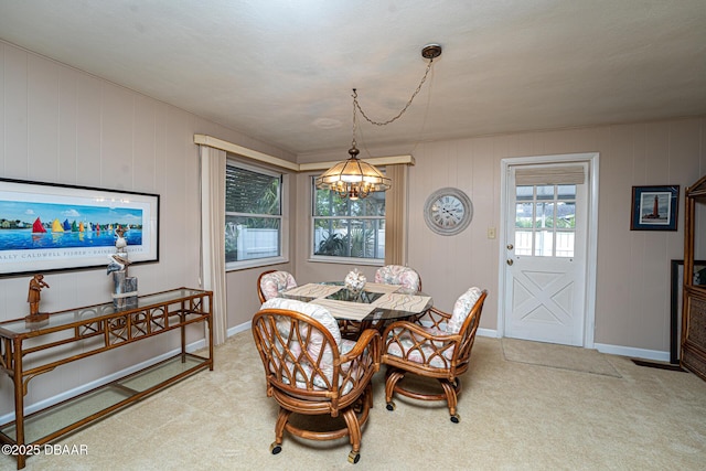 dining space featuring a chandelier, carpet floors, and baseboards