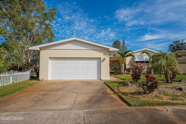 ranch-style home with a garage, concrete driveway, and fence