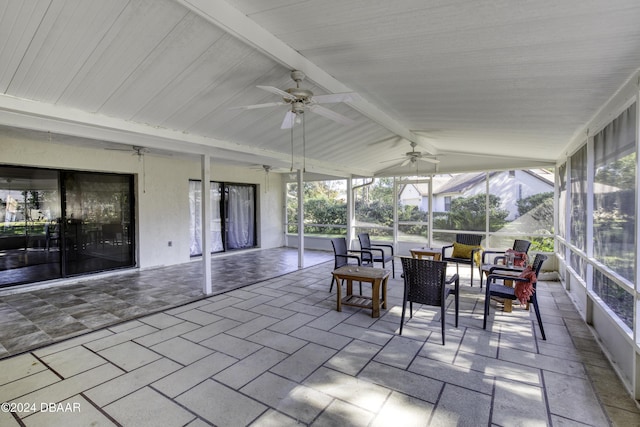 sunroom / solarium featuring ceiling fan and lofted ceiling with beams