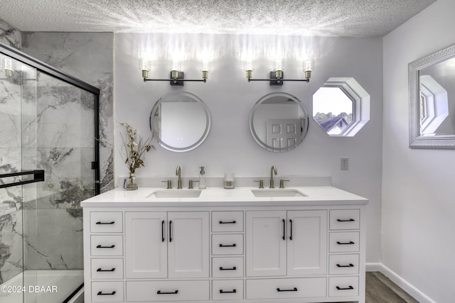 bathroom with hardwood / wood-style floors, vanity, and a textured ceiling