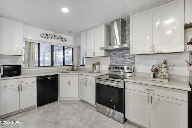 kitchen with a textured ceiling, white cabinetry, black appliances, and wall chimney range hood